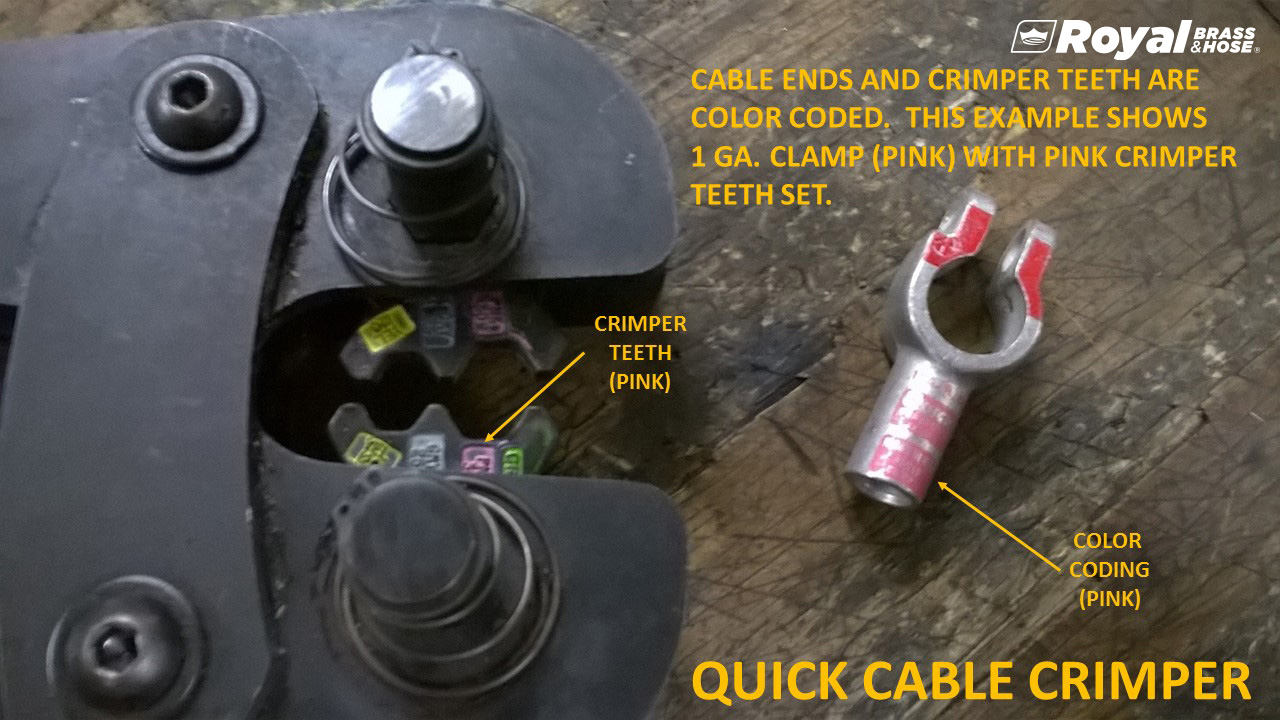 A close-up of a quick cable crimper tool and a cable clamp, illustrating the color-coded system for matching cable ends and crimper teeth. The crimper tool, positioned on the left, has pink crimper teeth, labeled "CRIMPER TEETH (PINK)." On the right, a cable clamp with pink color coding is labeled "COLOR CODING (PINK)." The text at the top of the image reads, "CABLE ENDS AND CRIMPER TEETH ARE COLOR CODED. THIS EXAMPLE SHOWS 1 GA. CLAMP (PINK) WITH PINK CRIMPER TEETH SET." The title at the bottom of the image reads, "QUICK CABLE CRIMPER," and the Royal Brass and Hose logo is visible in the top right corner. The setup is arranged on a wooden surface to clearly show the components and their color-coded system.