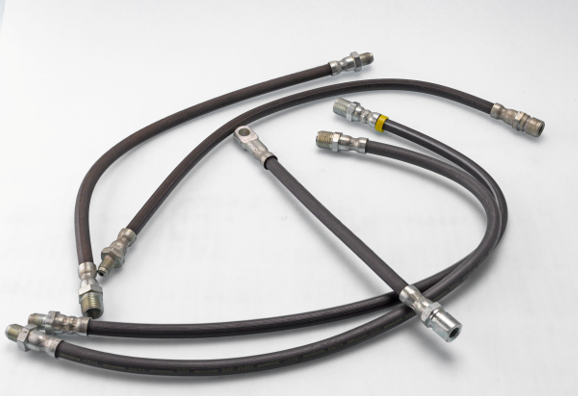 Several black rubber brake hoses with metal fittings and threaded connectors arranged on a white background, showcasing various lengths and end types.